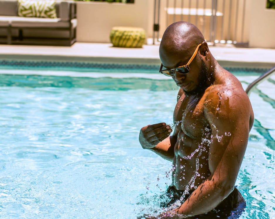 a man splashing swimming pool water on his body