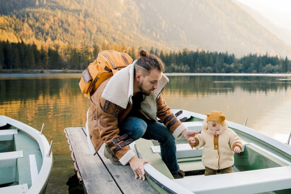 father with swim backpack in a boat with his son