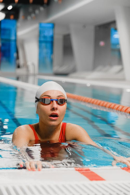 female swimmer swimming with a swim cap and goggles