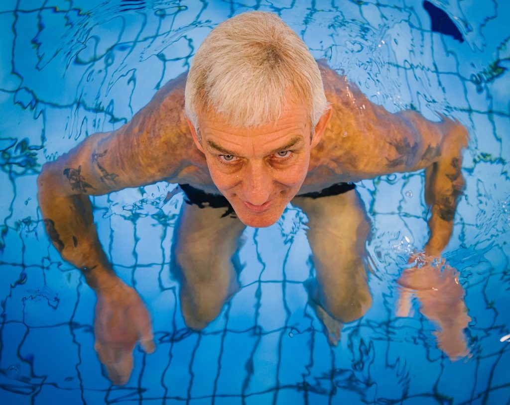 a man swimming as one of the shortest swimmers in the pool