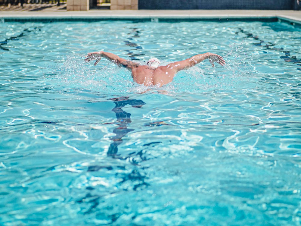 male swimmer practicing the butterfly stroke, and makng sure his arms move at the same time