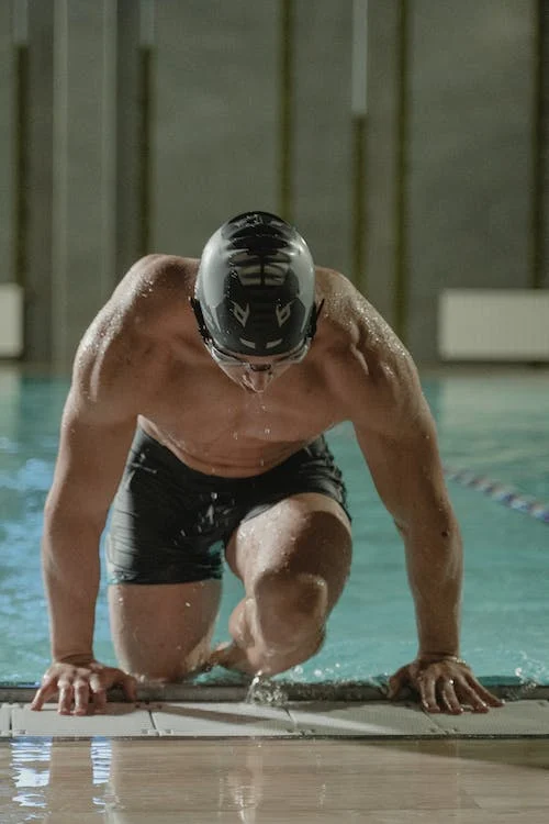 male swimmer holding a swim block