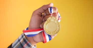 a person holding gold medal