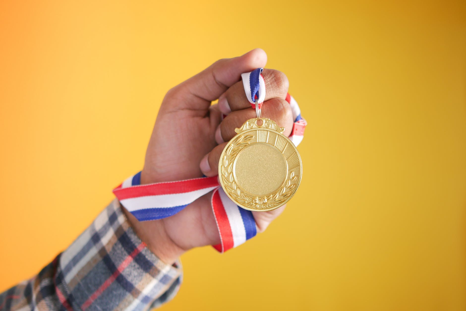 a person holding gold medal