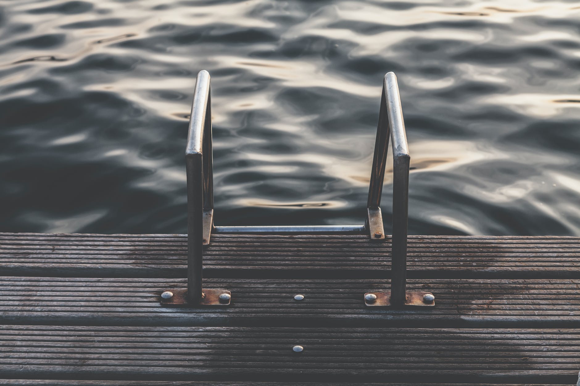 gray steel dock ladder beside body of water