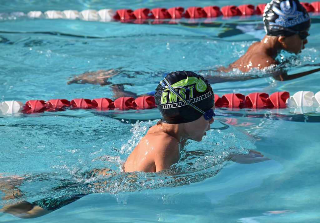 Two male young swimmers swimming competitively at a swim meet