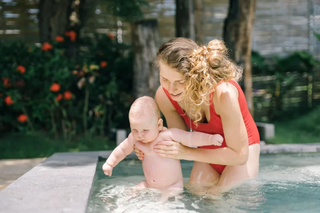 a mother teaching infants to swim in a pool